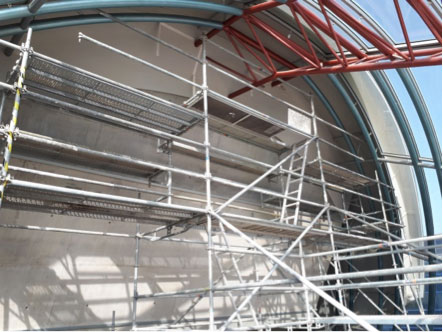 Un andamio especial para la impermeabilización de una bóveda metálica y andamio de acceso a un plano inclinado interior para reparación de filtraciones en paramento trasero del auditorio - Alquiansa